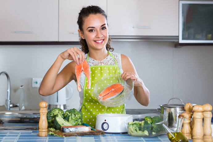 mujer en cocina mostrando alimentos ricos en omega3