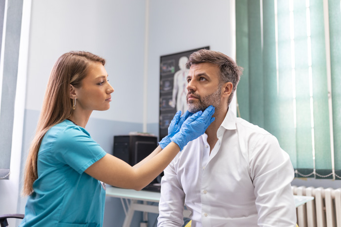 Médico examinando los pólipos en la garganta de un paciente.