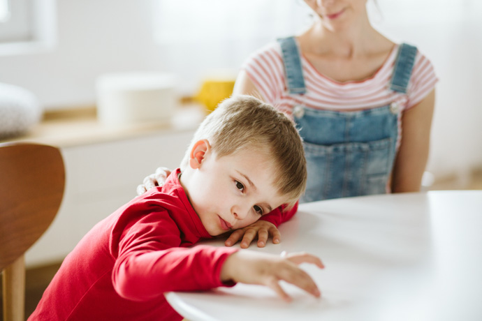 Niño con TDAH jugando con los dedos de la mano sobre la mesa.